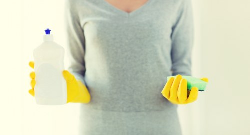 Staff member using protective equipment during oven cleaning